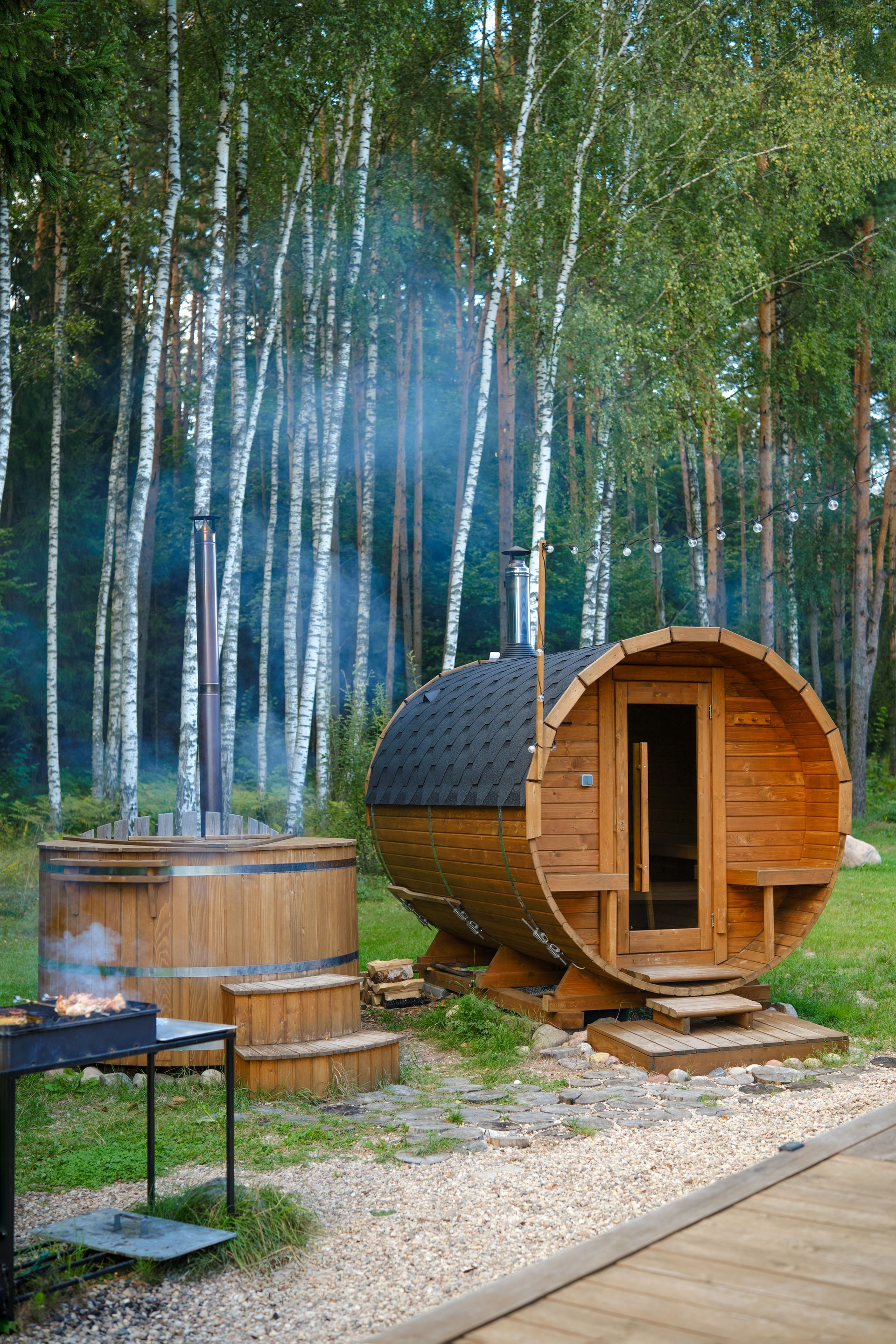 Outdoor barrel-shaped wooden sauna and hot tub